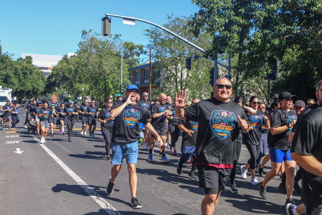 Runners wave during the Capitol leg of the 2026 Law Enforcement Torch Run.