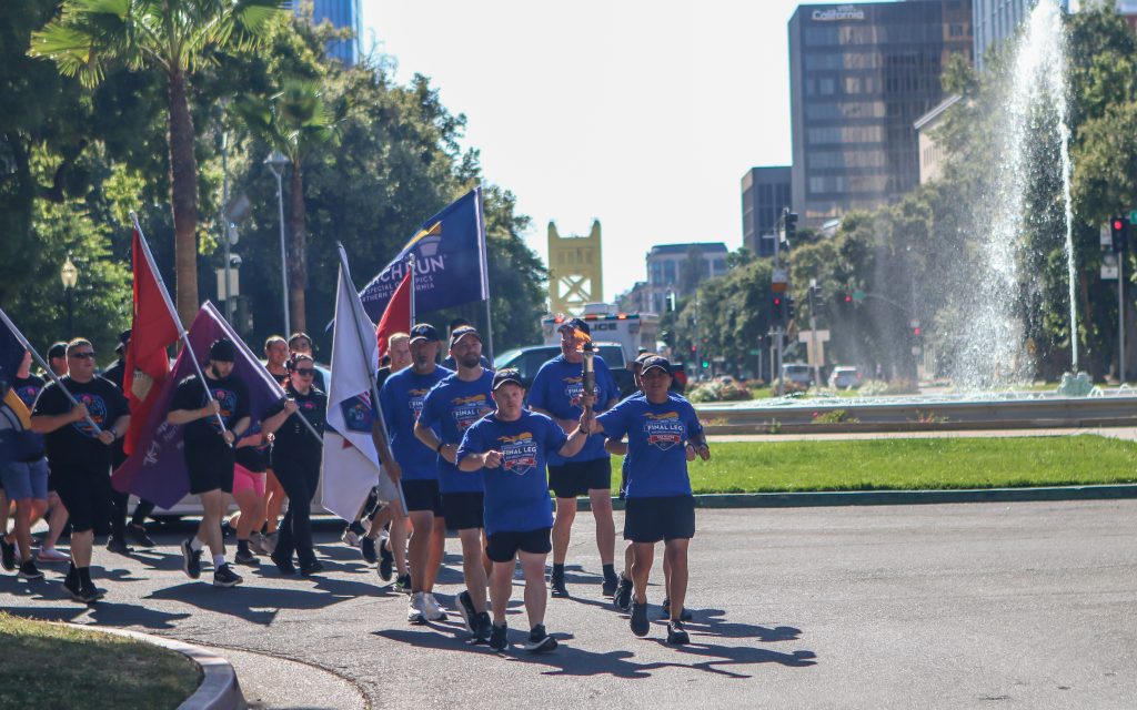 Special Olympics athlete and CDCR/CCHCS runners carry flags during the Capitol leg of the 2026 Law Enforcement Torch Run.