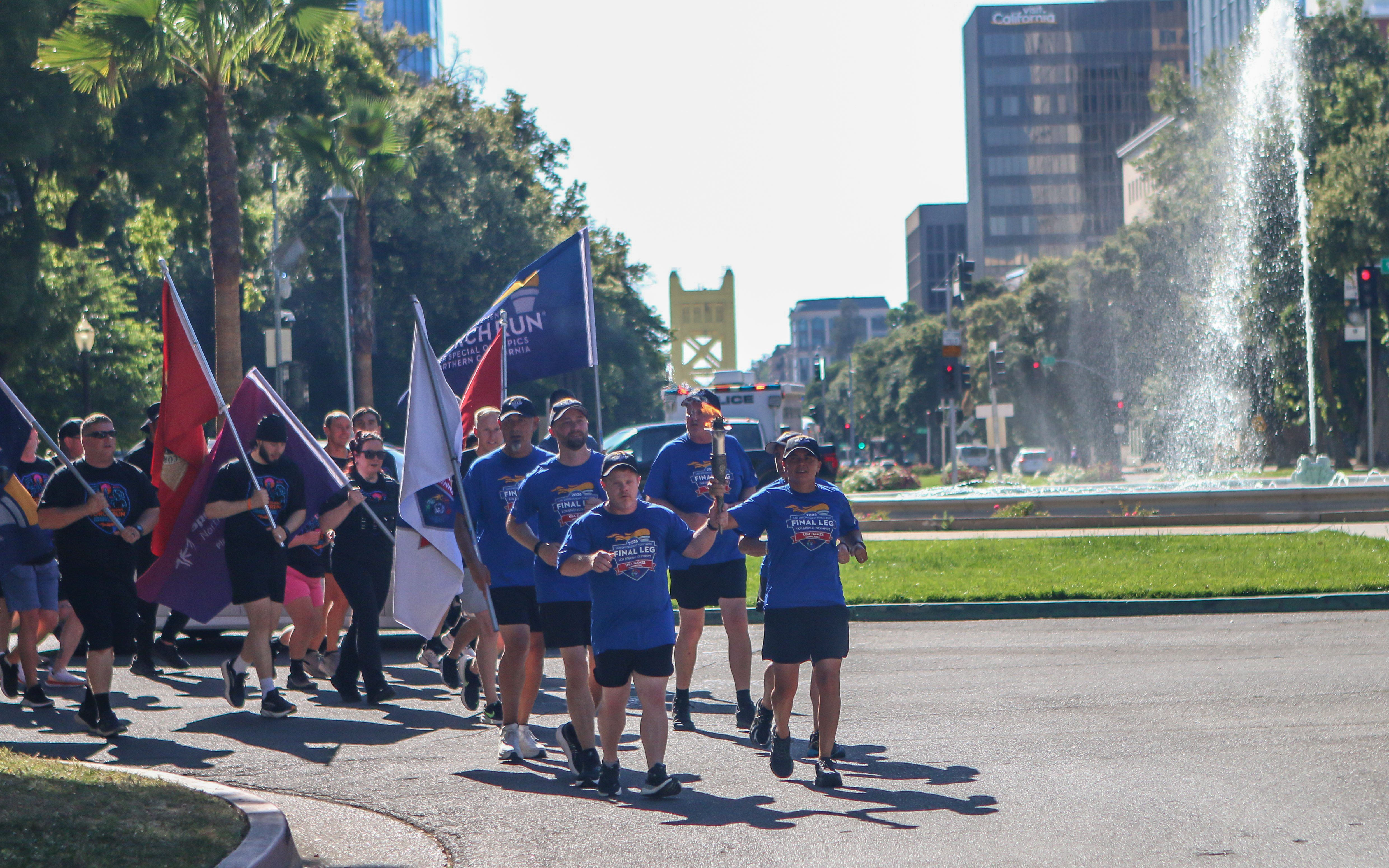 Special Olympics athlete and CDCR/CCHCS runners carry flags during the Capitol leg of the 2026 Law Enforcement Torch Run.