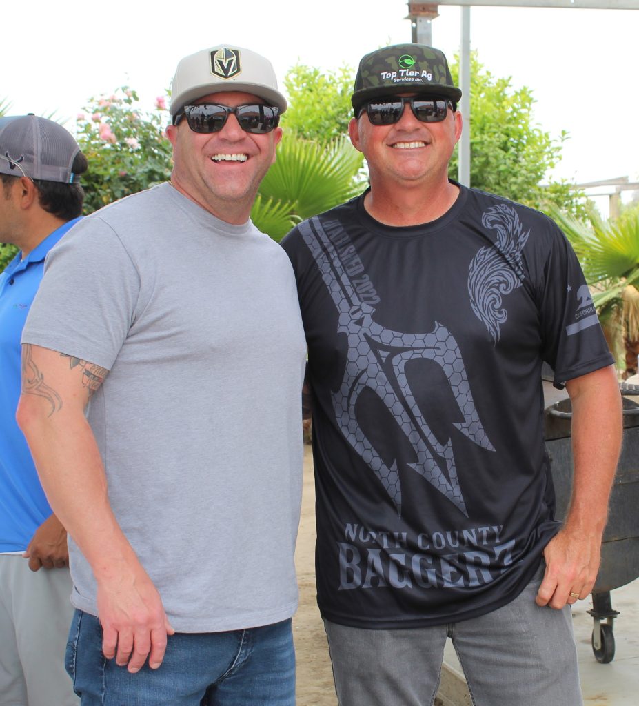 Two people smiling for the camera at the tournament with Pleasant Valley State Prison staff.