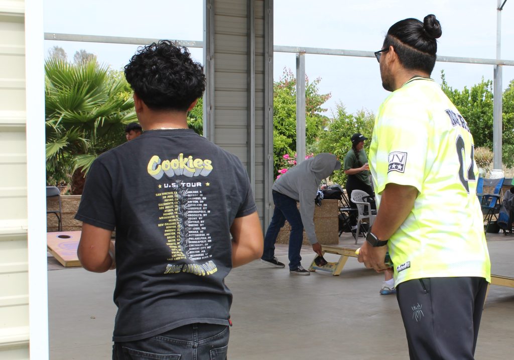 People playing cornhole.