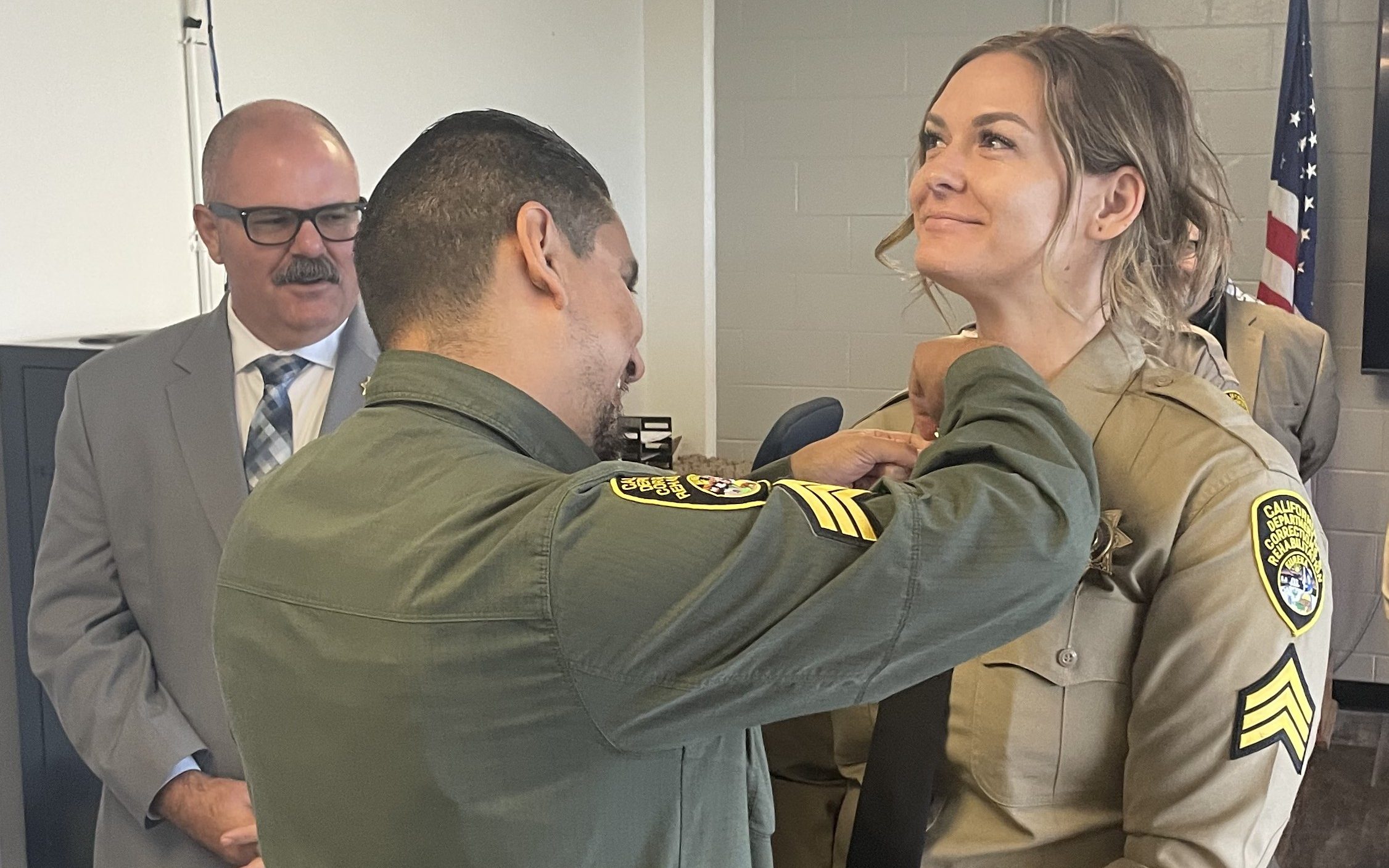 A new sergeant receives her rank insignia from a family member at CSP-Sacramento during a promotion ceremony in Folsom, California, 2026.