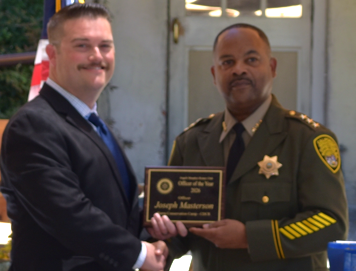 SCC Chief Deputy Warden presents Officer of Year Award to Masterson for actions taken late last year to assist a car crash victim.