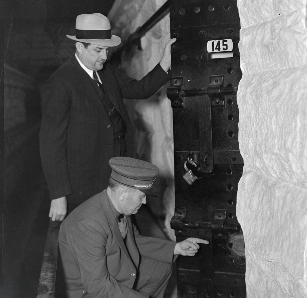 Warden Clarence Larkin and Turnkey Buchanan examine the holes drilled into the steel door at Folsom State Prison in a failed escape attempt in March 1937. UC Berkeley Bancroft Library photo.