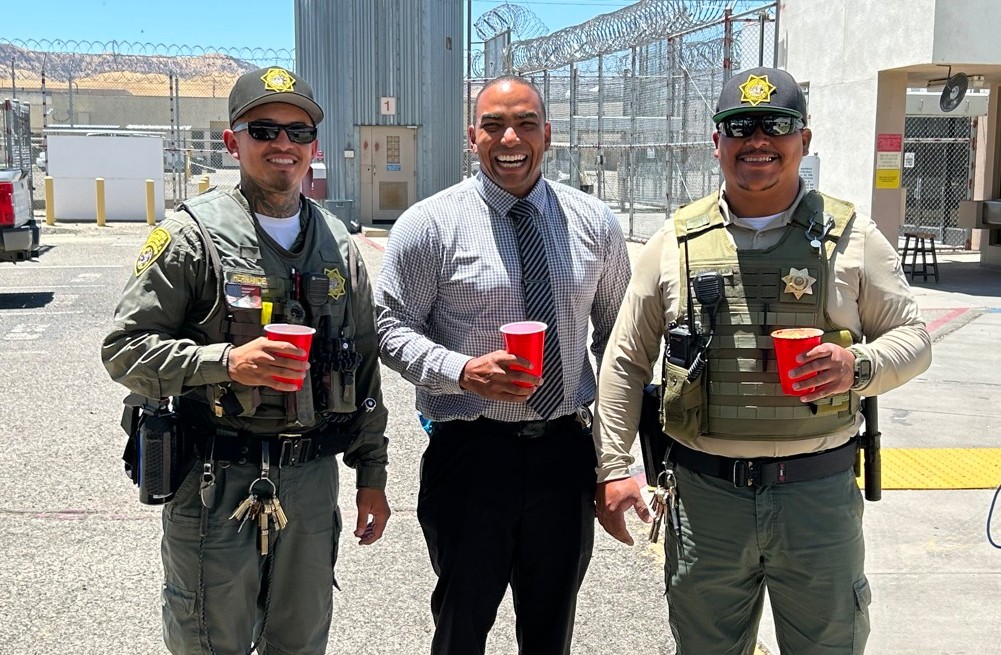 Three staff members smiling at Avenal State Prison.