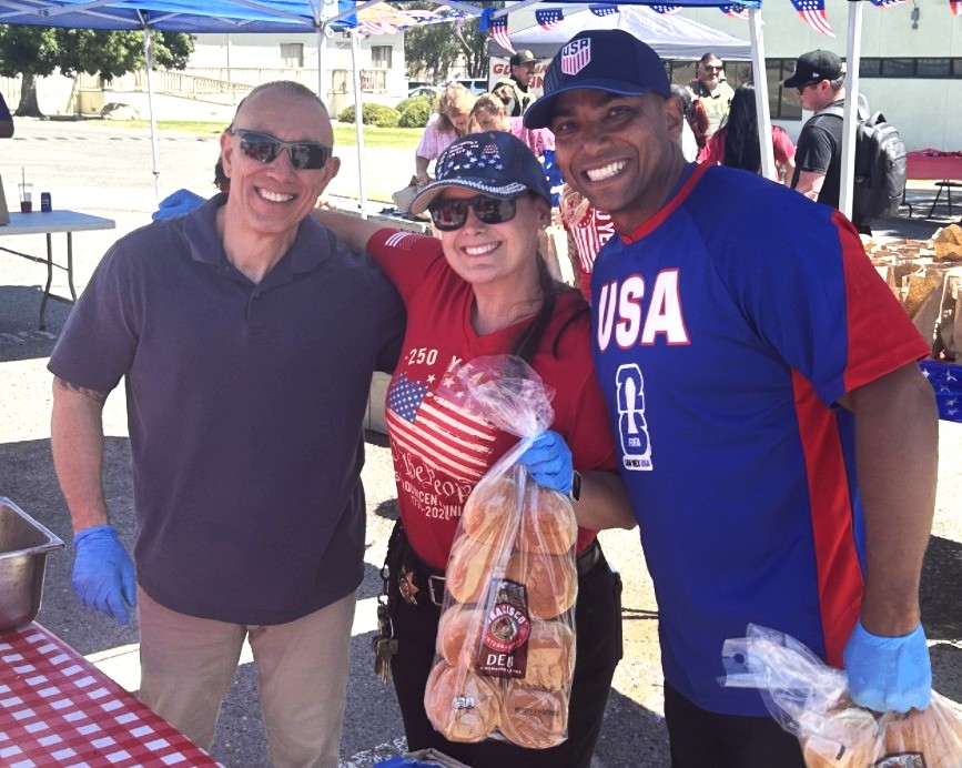 Three people smiling at a staff appreciation event at Avenal State Prison, July 2, 2024.