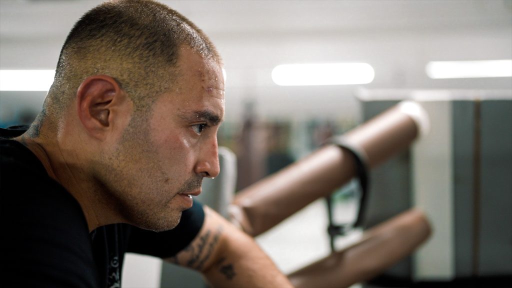 Man in boxing ring with sweat dripping off his nose.