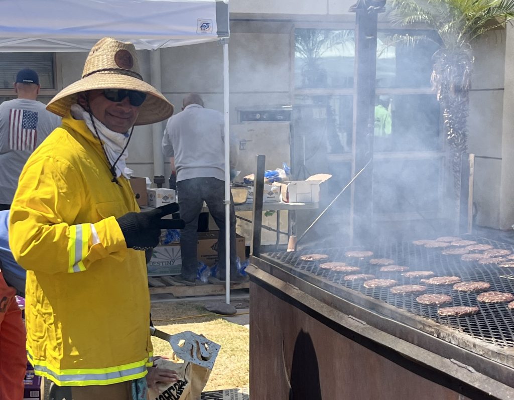 Wearing yellow, a person works the grill at Calipatria State Prison, July 1, 2026.