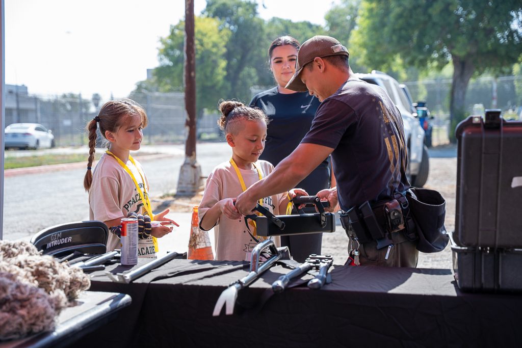 A staff member shows a young cadet a battering ram at CIM for the Junior Academy.
