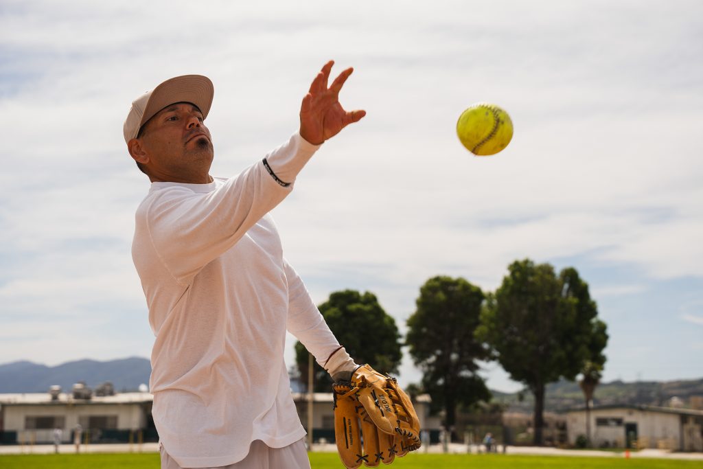 An incarcerated person throws a softball at California Institution for Men in Chino.