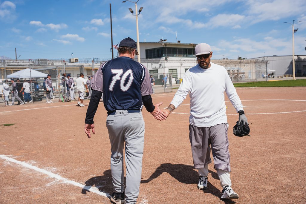 Saints player shakes hands with a CIM incarcerated person.