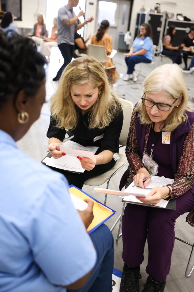 Volunteer judges evaluate a participant's business pitch at CIW.