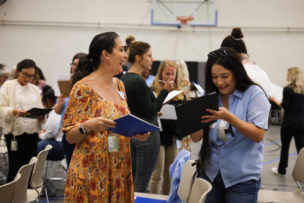 A community volunteer assists a participant in the Defy Ventures program.