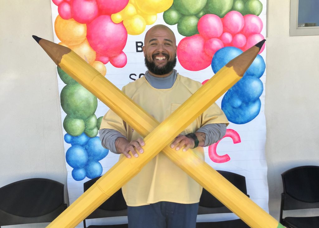 Participant in front of CSP Solano back to school backdrop