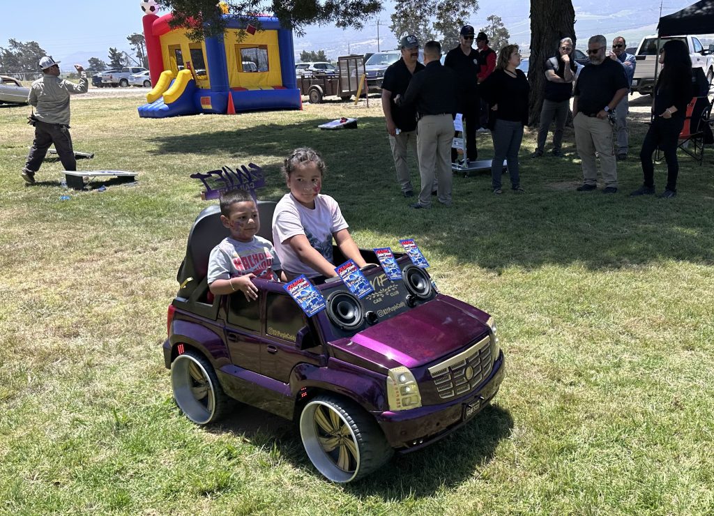 Kids ride in a small battery-powered toy car at CTF's staff appreciation event. 