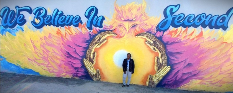 Woman standing in front of a mural about second chances.