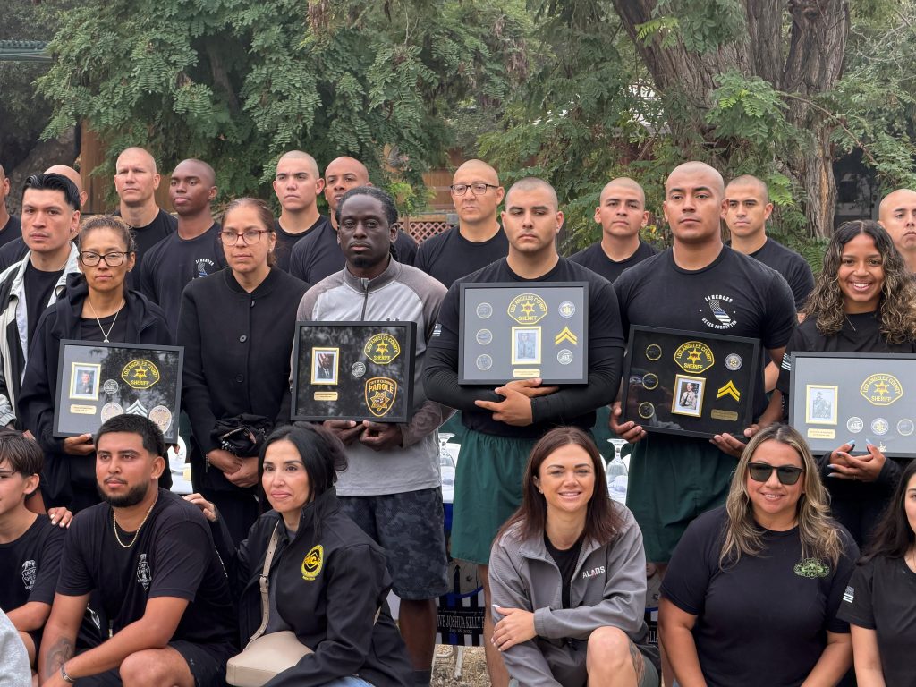 Group photo of people holding shadow boxes honoring fallen officers as well as Parole Agent Joshua Byrd.