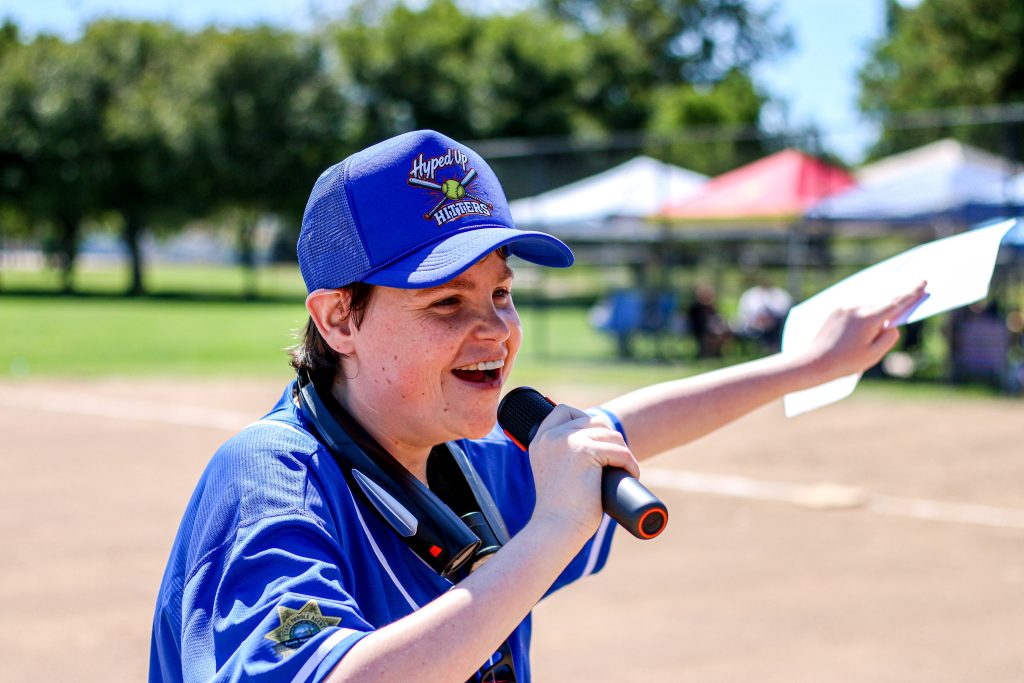 A person wearing a blue team outfit speaks into the microphone. 