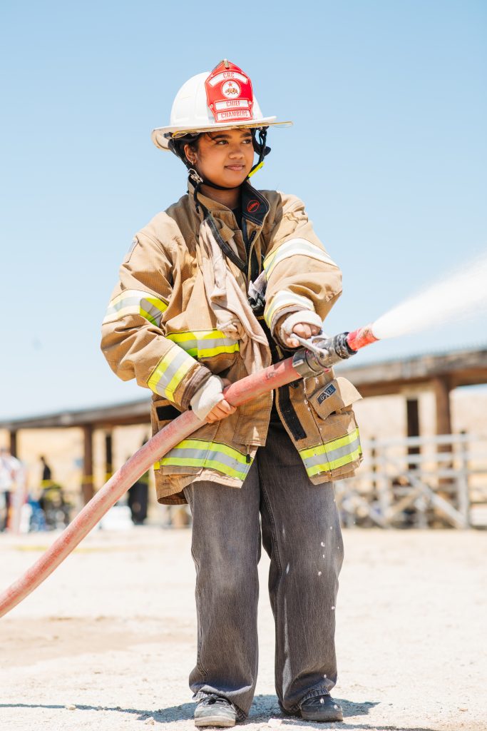 A child uses a fire hose during a staff appreciation family day at LAC in Lancaster.