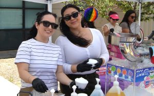 Two staff members prepare snow cones for event attendees at LAC.
