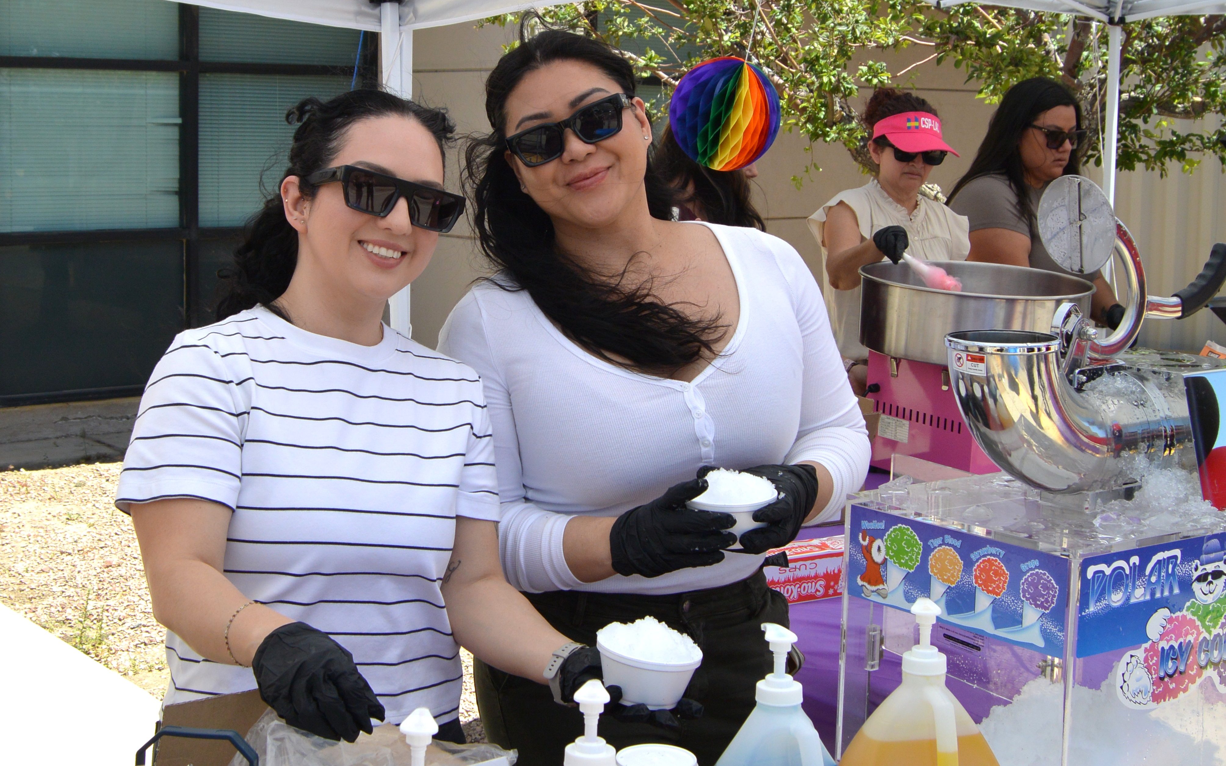 Two staff members prepare snow cones for event attendees at LAC.