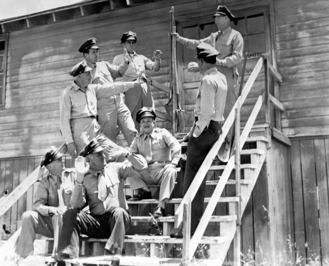 Correctional officers on the steps of one of the original buildings at Camp Barracks in the 1950s, later South Facility. The building was later demolished.