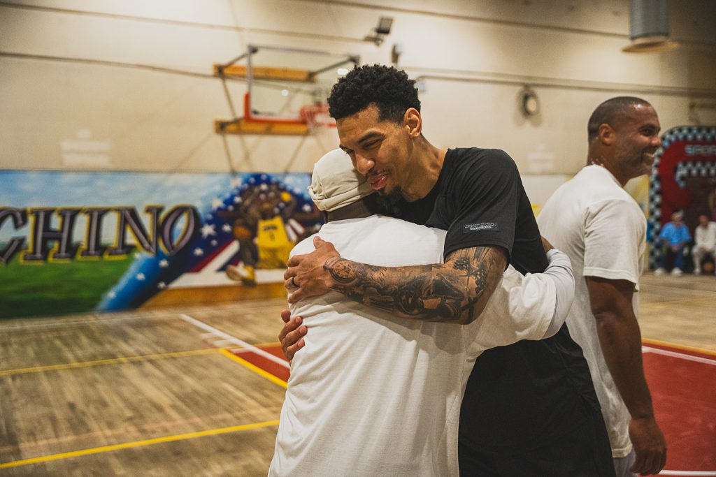 Hug between an incarcerated player and a member of Between the Lines at CIM at Chino, California.