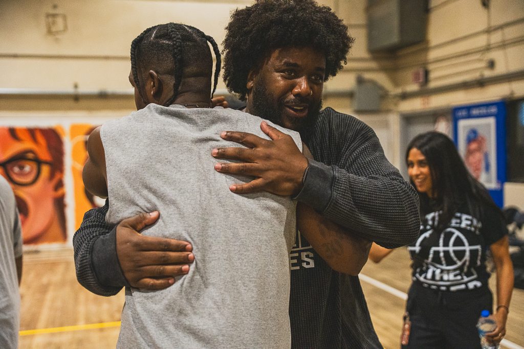 Hug between an incarcerated player and a member of Between the Lines at CIM at Chino, California.