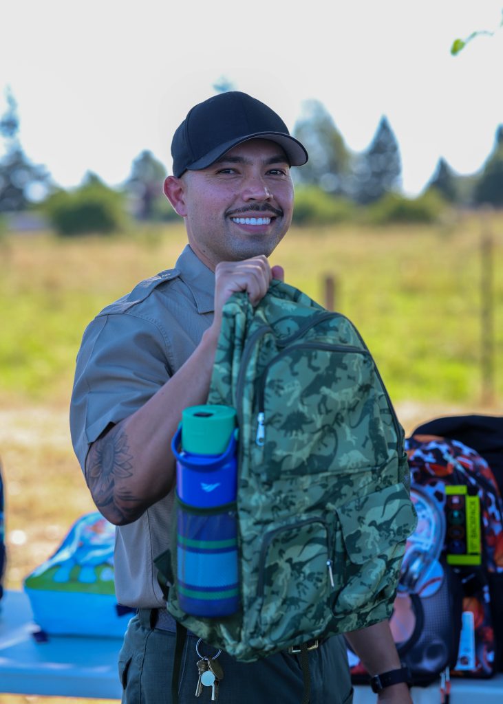 A cadet holds a backpack during the Badges and Backpacks giveaway at the CDCR Academy in Galt, California.