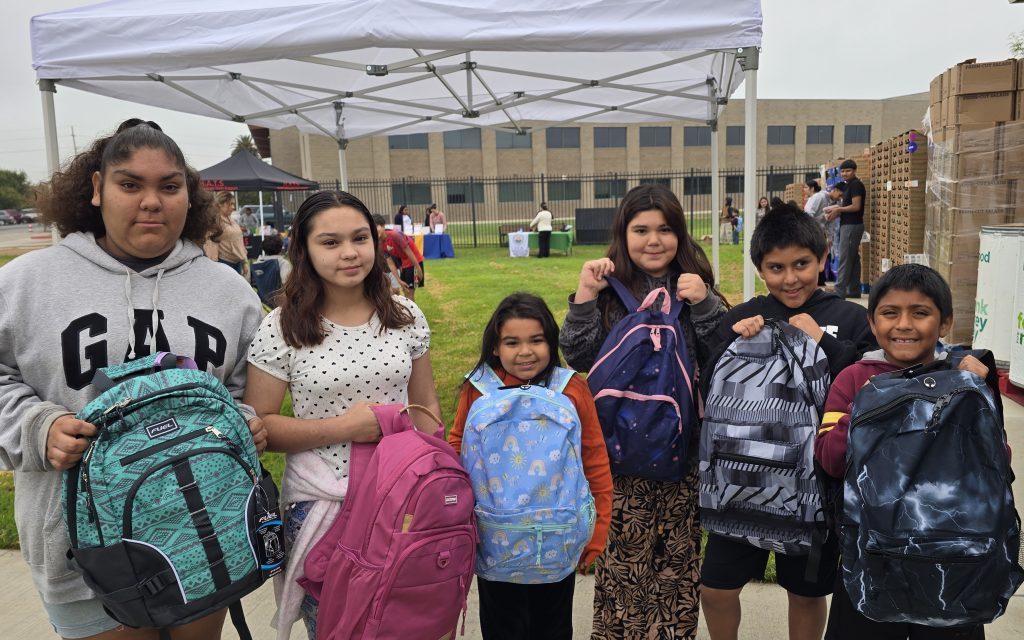 Children show off their new backpacks in Soledad, California, donated by the Correctional Training Facility staff.