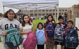 Children show off their new backpacks in Soledad, California, donated by the Correctional Training Facility staff.