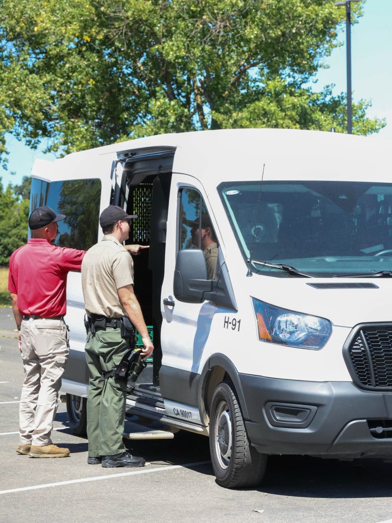 A cadet checks out the inside of a CDCR transportation vehicle.