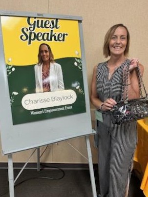 Speaker Charisse Blaylock at event, posing in front of her poster