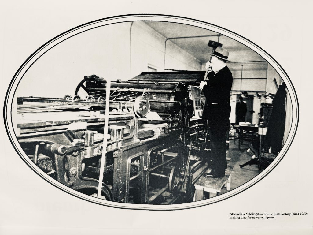 Warden Robert Heinze in the license plate factory in 1950 as the institution prepares to receive new equipment.