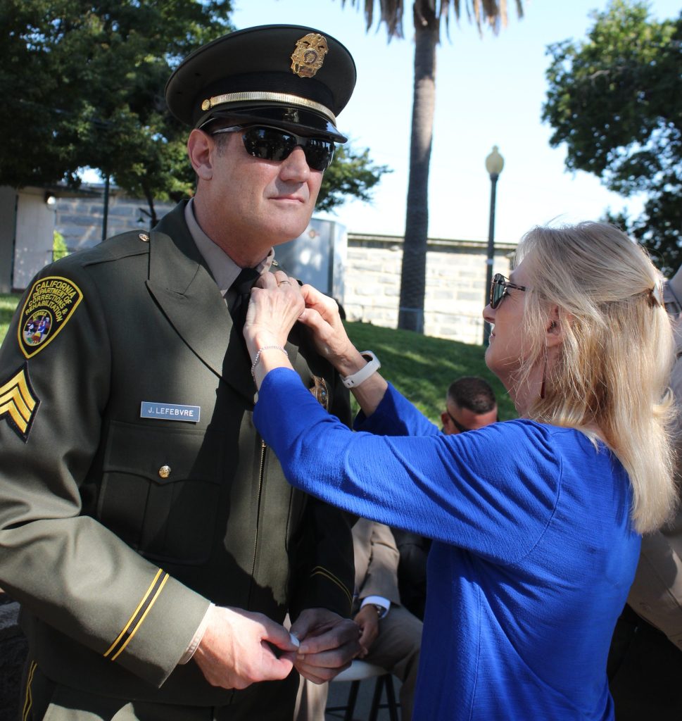 A new sergeant receives his rank insignia from a family member at Folsom State Prison, July 31, 2026.