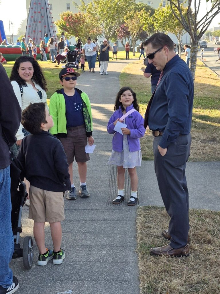 A staff member from Pelican Bay State Prison speaks to children at National Night Out in Crescent City, California, Aug. 4, 2026.