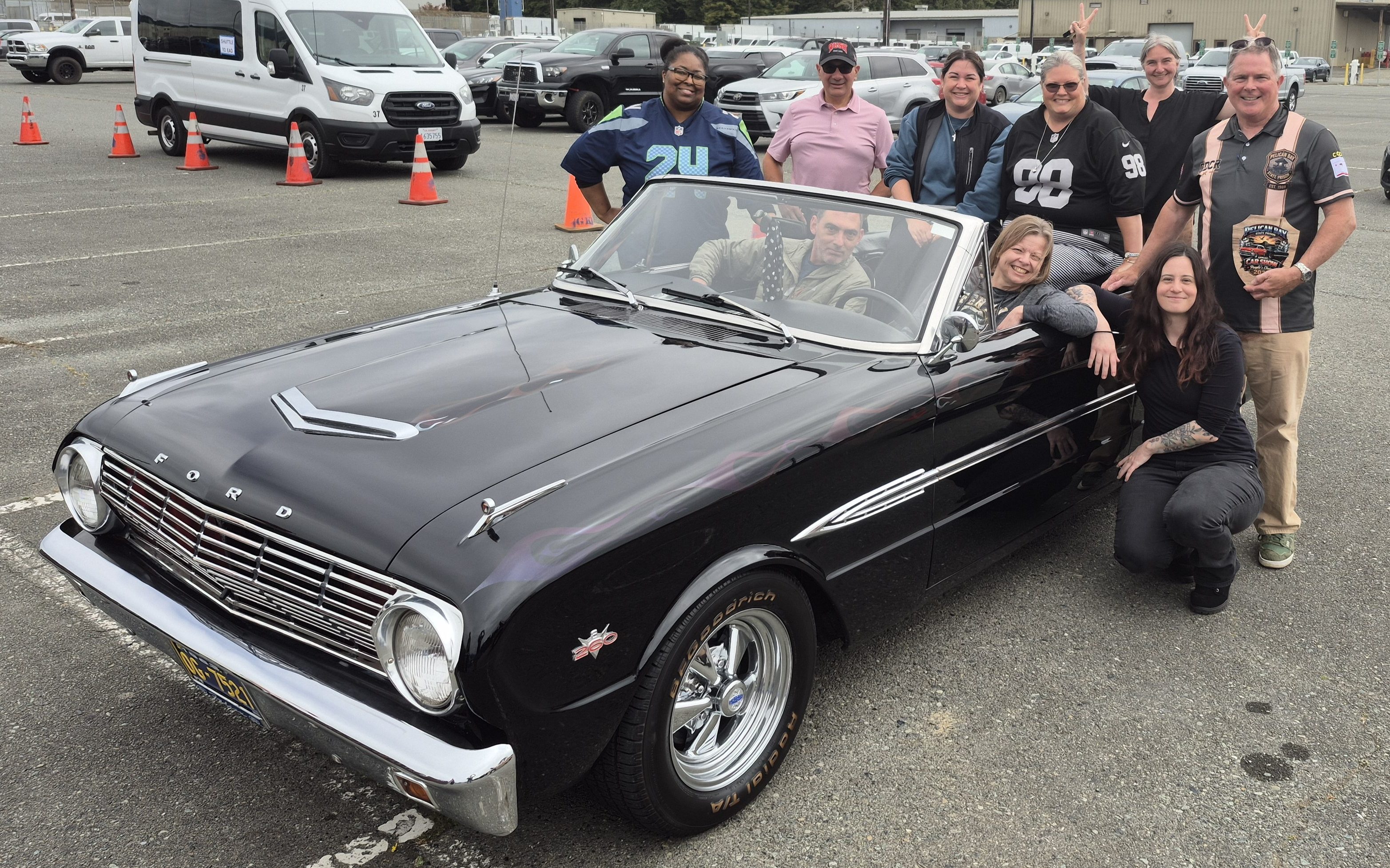 Group photo of Pelican Bay State Prison staff around a classic car.