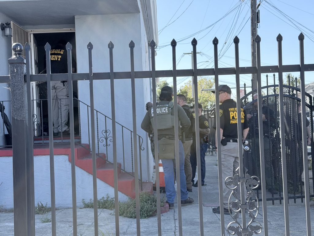 Parole agents sweep a house for compliance.