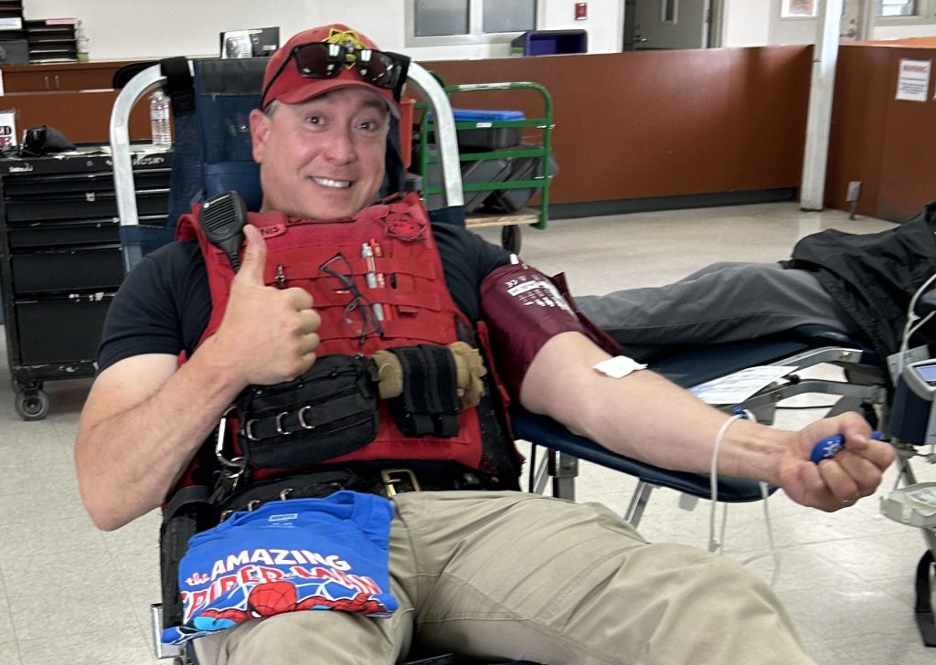 An RJD staff member gives a thumbs-up at a blood drive.