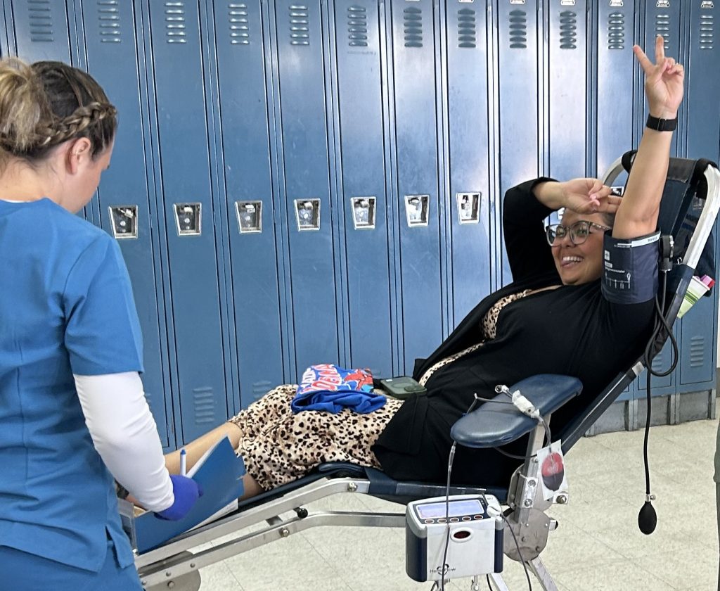 A woman is smiling as she prepares to donate blood at RJD.