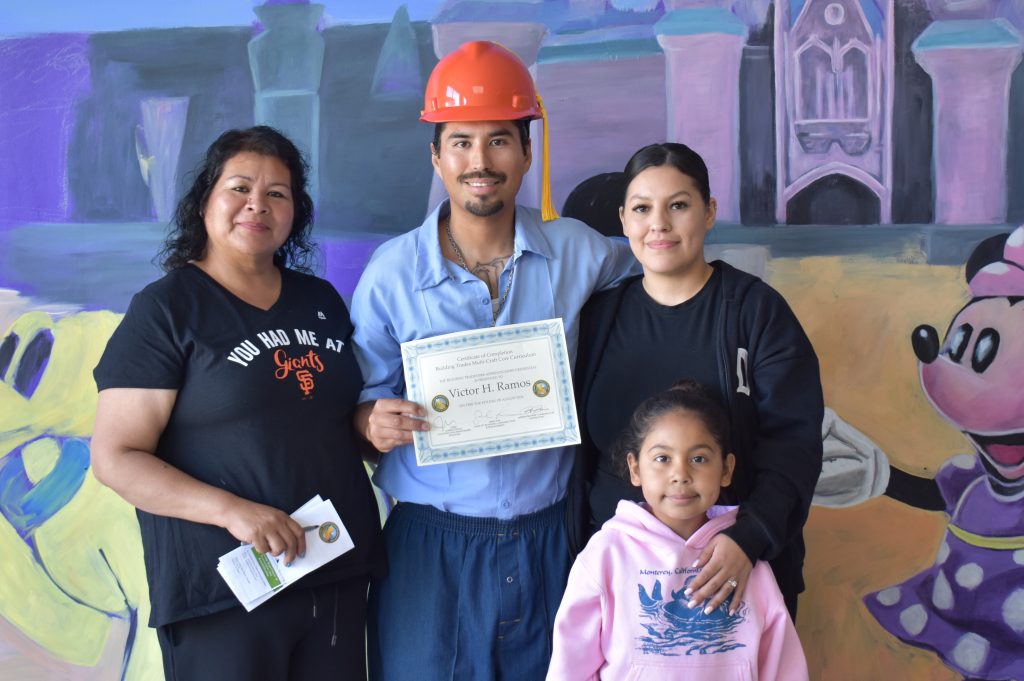 An incarcerated man wearing a hardhat with three other family members at SVSP for construction program.