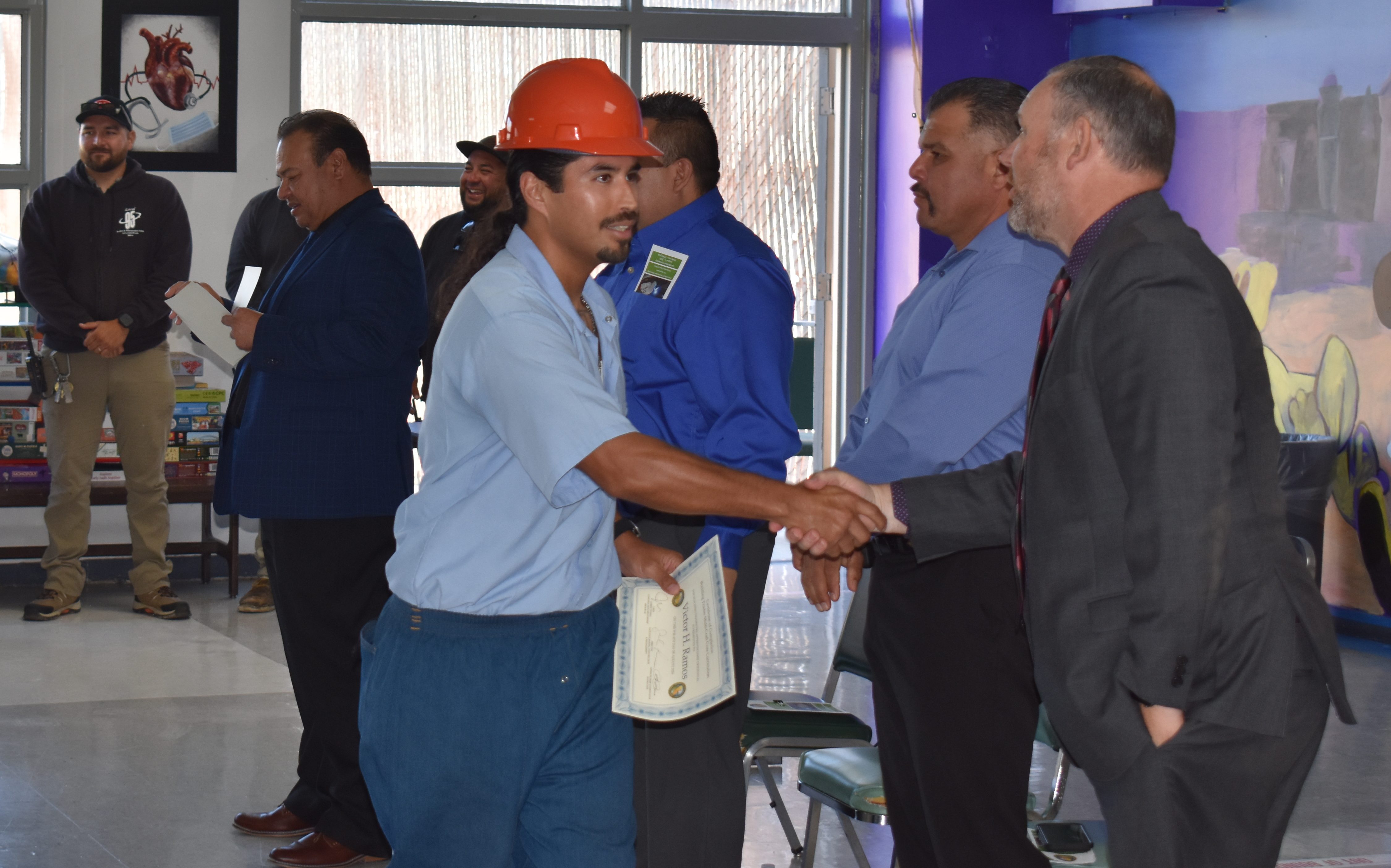 An incarcerated person shakes hands with CDCR officials after graduating the correctional construction mentorship program at Salinas Valley State Prison in Soledad, California.
