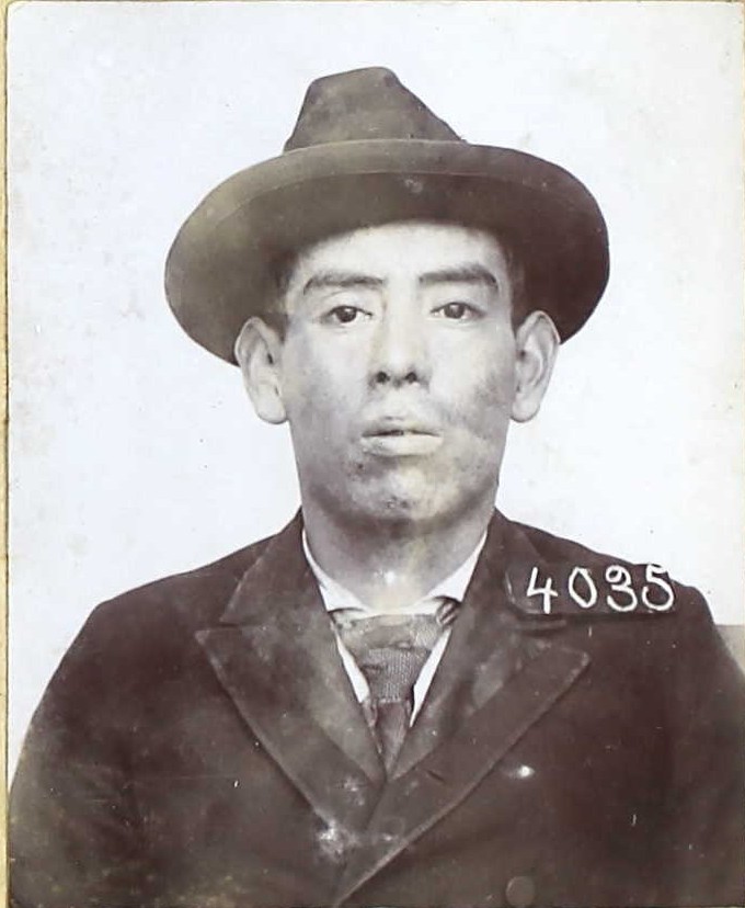 Augustine Berryessa wearing a hat while having his prison photo taken in 1897.