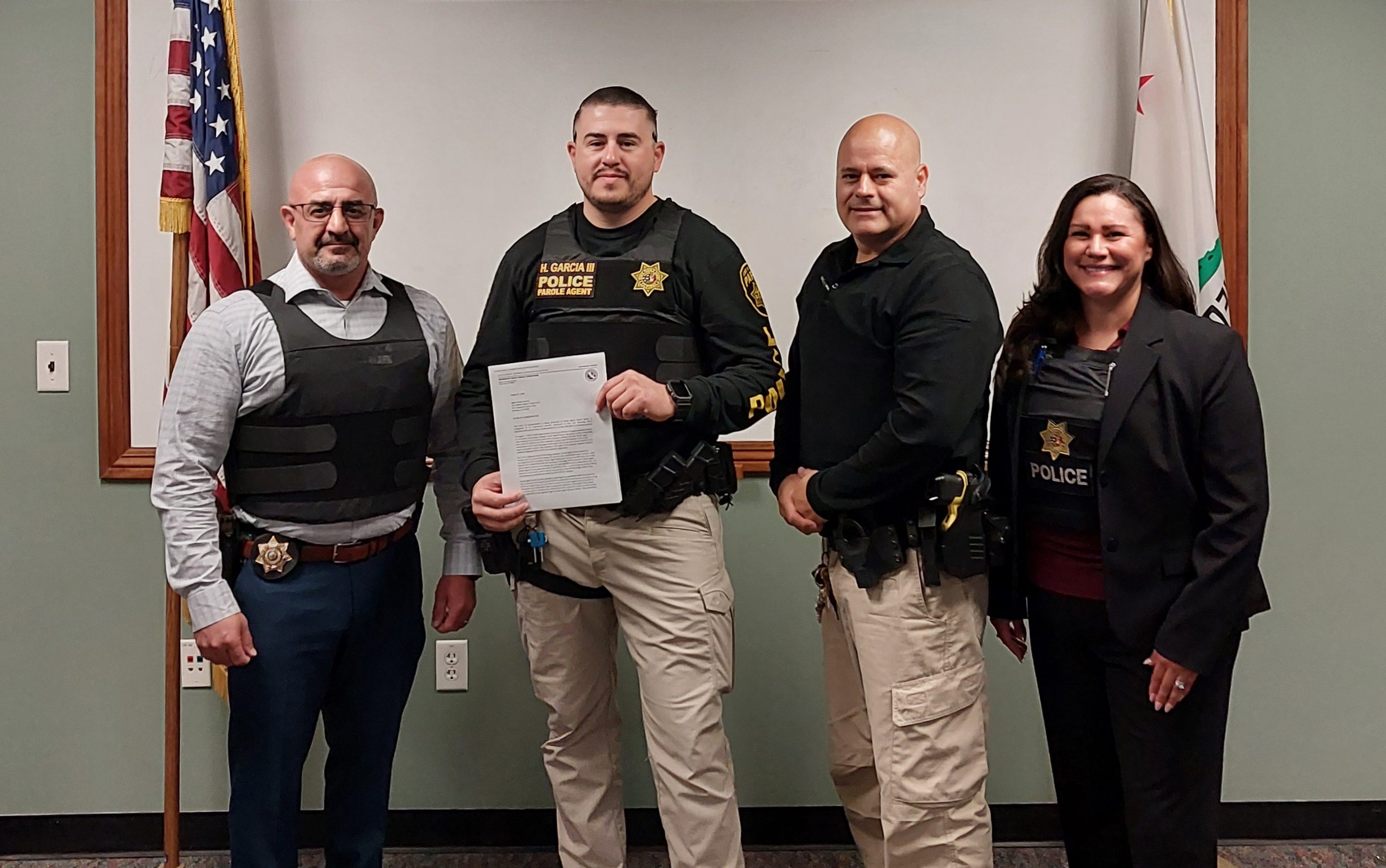 Parole Agent Hector Garcia, center, was recognized by his supervisors for saving a teenager who was threatening to jump from a freeway overpass.