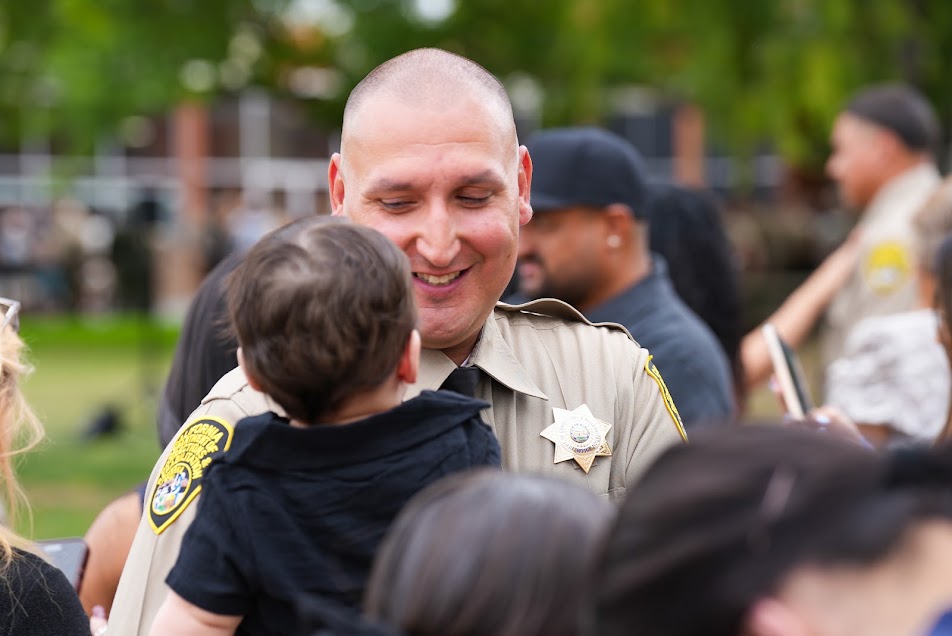 A new correctional officer holds a child after the graduation.