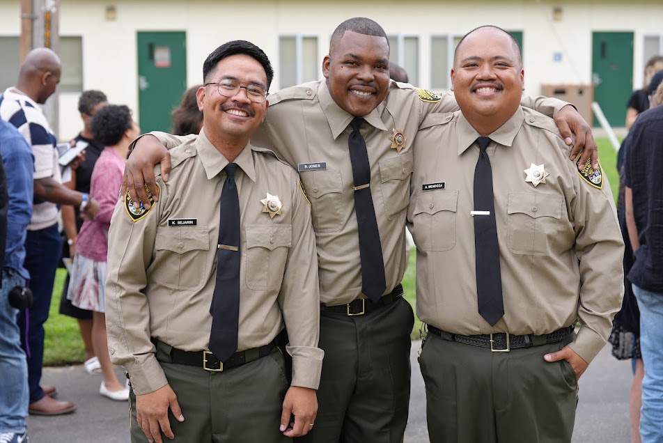Three new correctional officers celebrate.