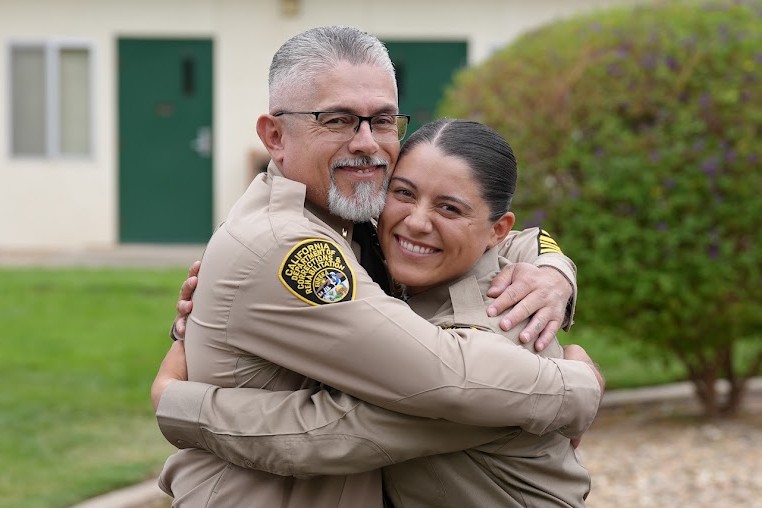A daughter and her father hug after Class 3-26A graduated.