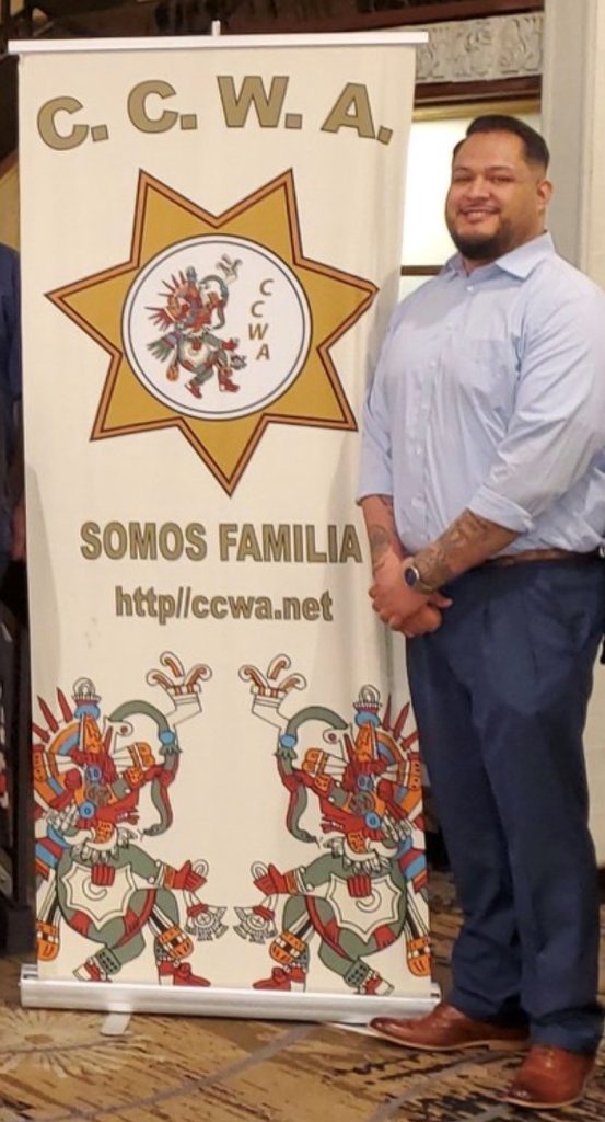 Nicholas Gonzales with CCWA Somos Familia banner
