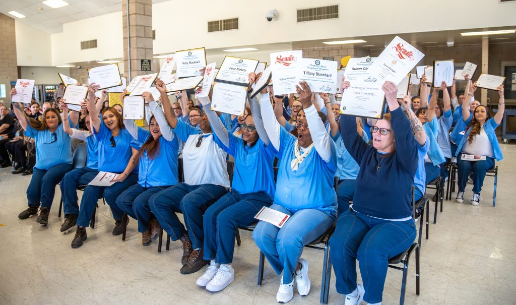 Graduates hold their certificates of completion at CCWF.
