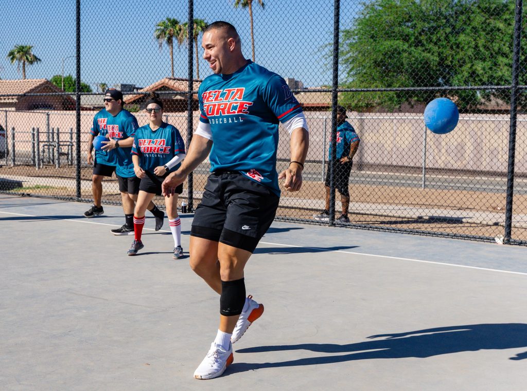 Dodgeball Tournament with a person dodging a ball as it flies by him.